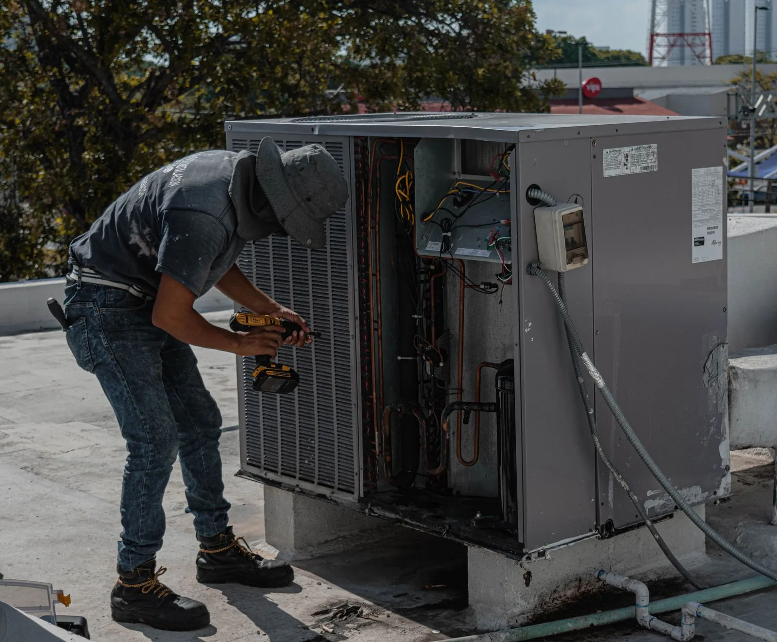 Technician working on an outdoor air conditioning unit